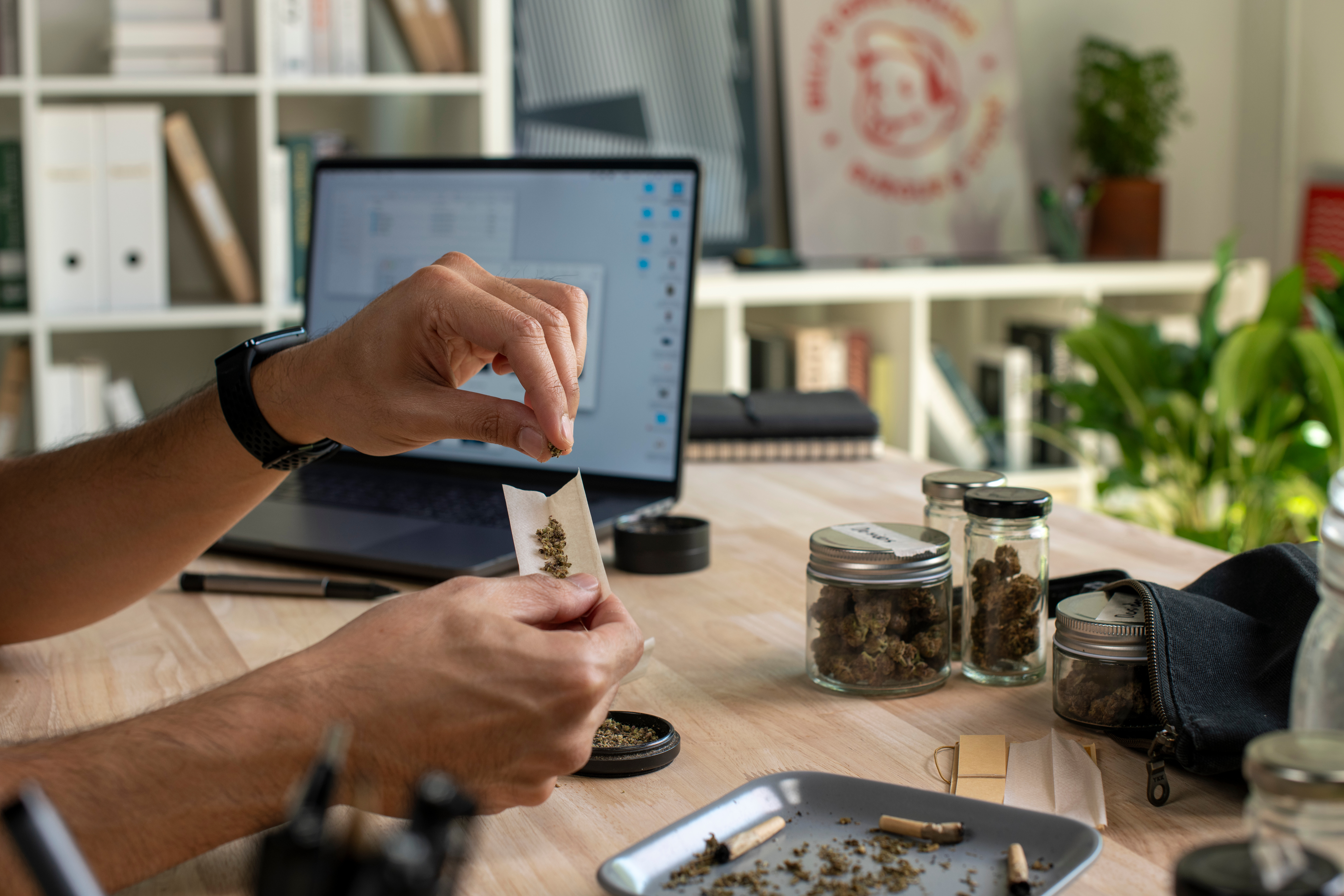 Personne qui roule un joint de cannabis sur son bureau. ©amenic181 | Adobe Stock